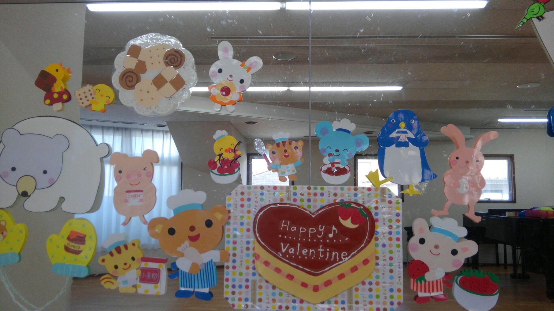 教室壁面に貼られた装飾イラスト。今度はうってかわって動物さん達がお菓子作りをしています。真ん中には「Happy Valentine」と書かれたケーキがあります。
